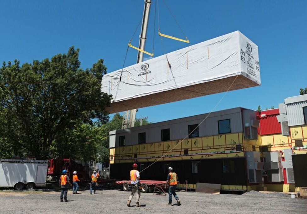 grue descendant un bâtiment modulaire en place