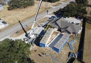 A crane from the modular construction industry lifts a temporary modular node onto the ground node with care