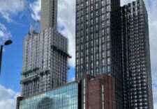 De grands gratte-ciel modernes en construction avec des grues sur fond de ciel bleu et de nuages épars