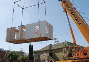 grue descendant une maison modulaire sur les fondations